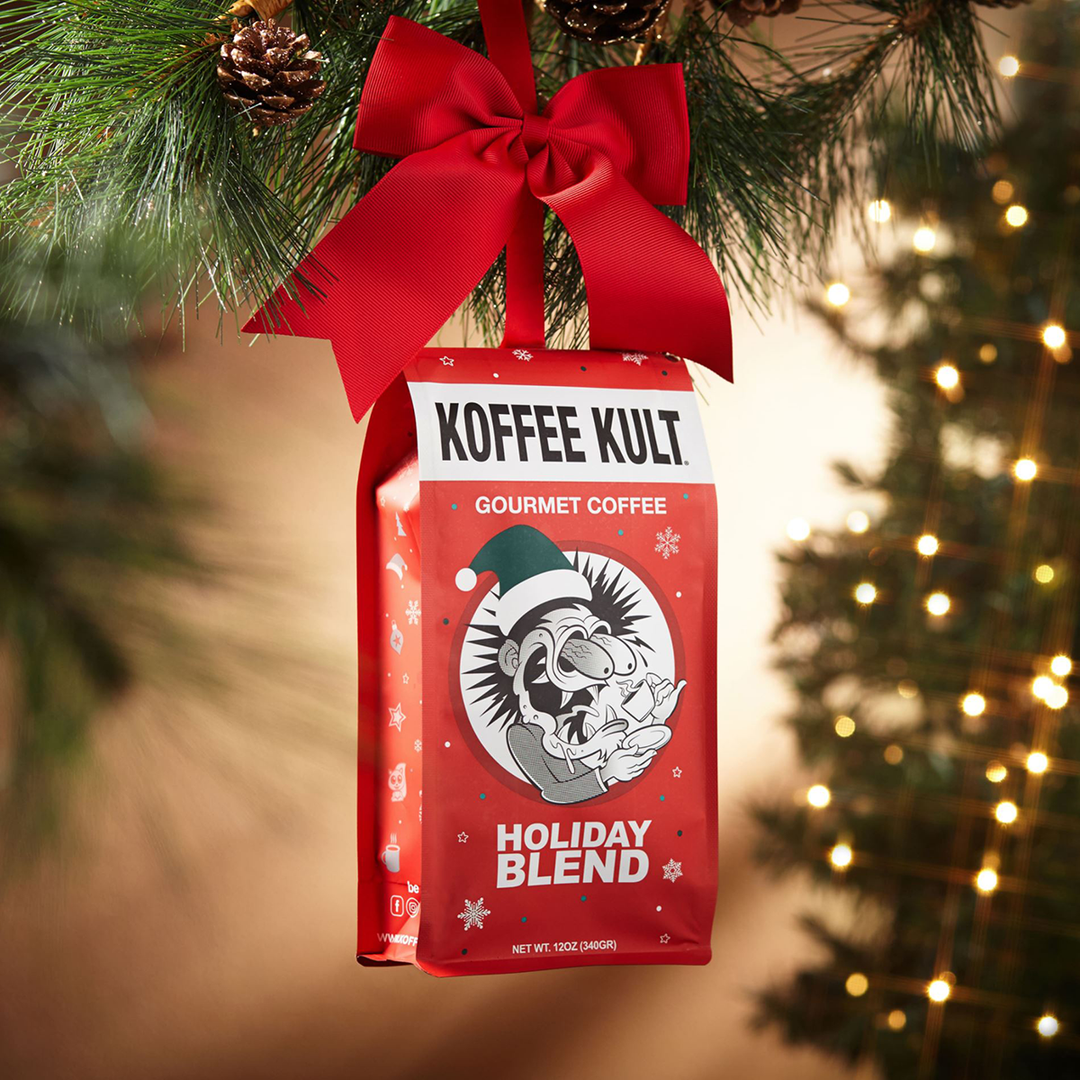 Koffee Kult Holiday Blend coffee bag with a red bow hanging on a Christmas tree.