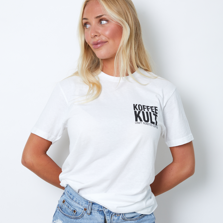 Person wearing a white t-shirt with 'Koffee Kult' text on a plain background