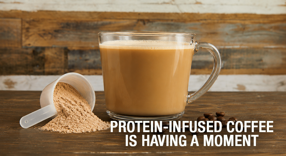 Glass of protein-infused coffee with a scoop of protein powder on a wooden surface.