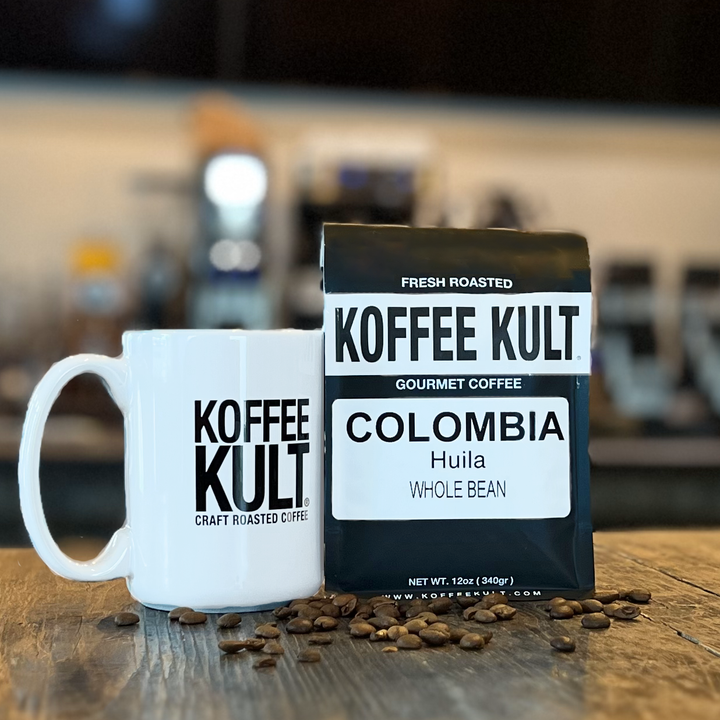 Koffee Kult coffee bag and mug with coffee beans on a wooden surface