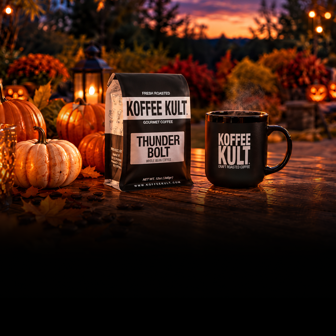 A bag of Koffee Kult Thunder Bolt coffee and a matching black mug with Koffee Kult branding sit on a wooden patio table at dusk, surrounded by pumpkins, string lights, and a fire pit in an outdoor backyard setting, with black gradient at bottom of the image. 