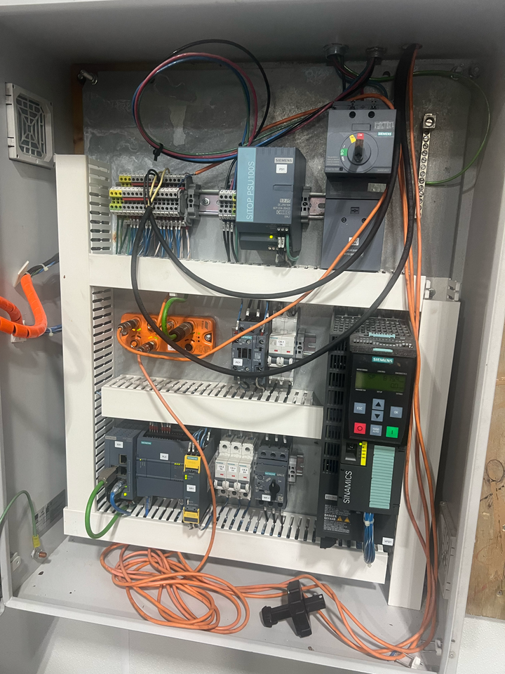 Electrical panel with various components and wiring inside a cabinet